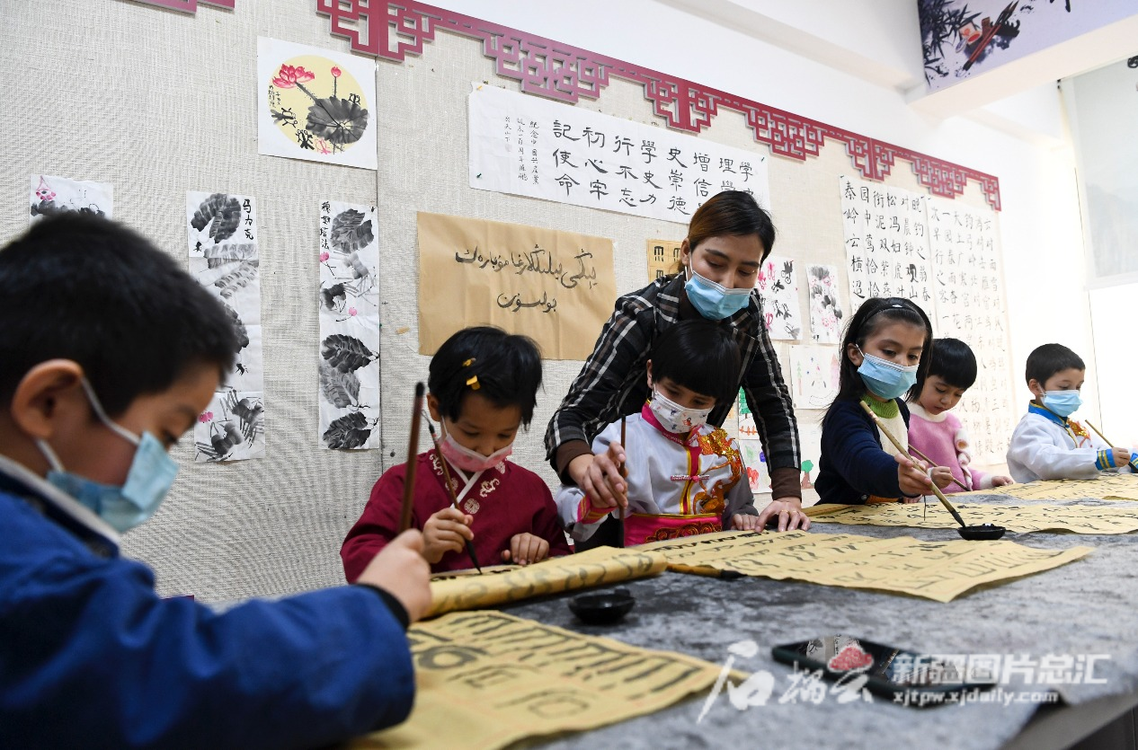 2022年1月14日，小朋友在烏魯木齊市天山區(qū)二道橋街道固原巷社區(qū)開辦的“六點(diǎn)半”課堂學(xué)習(xí)書法。  石榴云/新疆日?qǐng)?bào)記者 湯永攝