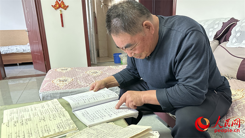 青格達湖鄉(xiāng)天山村村民李強拿出近幾年的賬本查看。人民網(wǎng)記者 楊睿攝