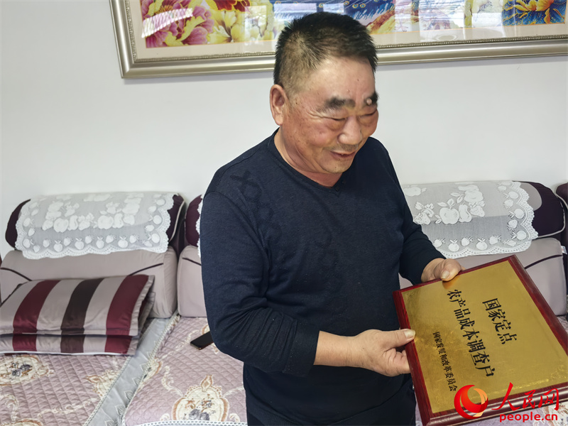 李強向記者展示他獲得的“國家定點農(nóng)產(chǎn)品成本調(diào)查戶”牌匾。人民網(wǎng)記者 陳新輝攝