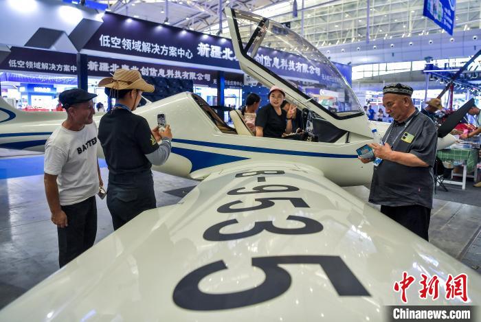 6月27日，新疆烏魯木齊市，正在新疆國(guó)際會(huì)展中心舉行的2025（中國(guó)）亞歐商品貿(mào)易博覽會(huì)低空經(jīng)濟(jì)產(chǎn)業(yè)展館，參觀者坐進(jìn)一架小型飛機(jī)駕駛艙體驗(yàn)、拍照。中新社記者 劉新 攝